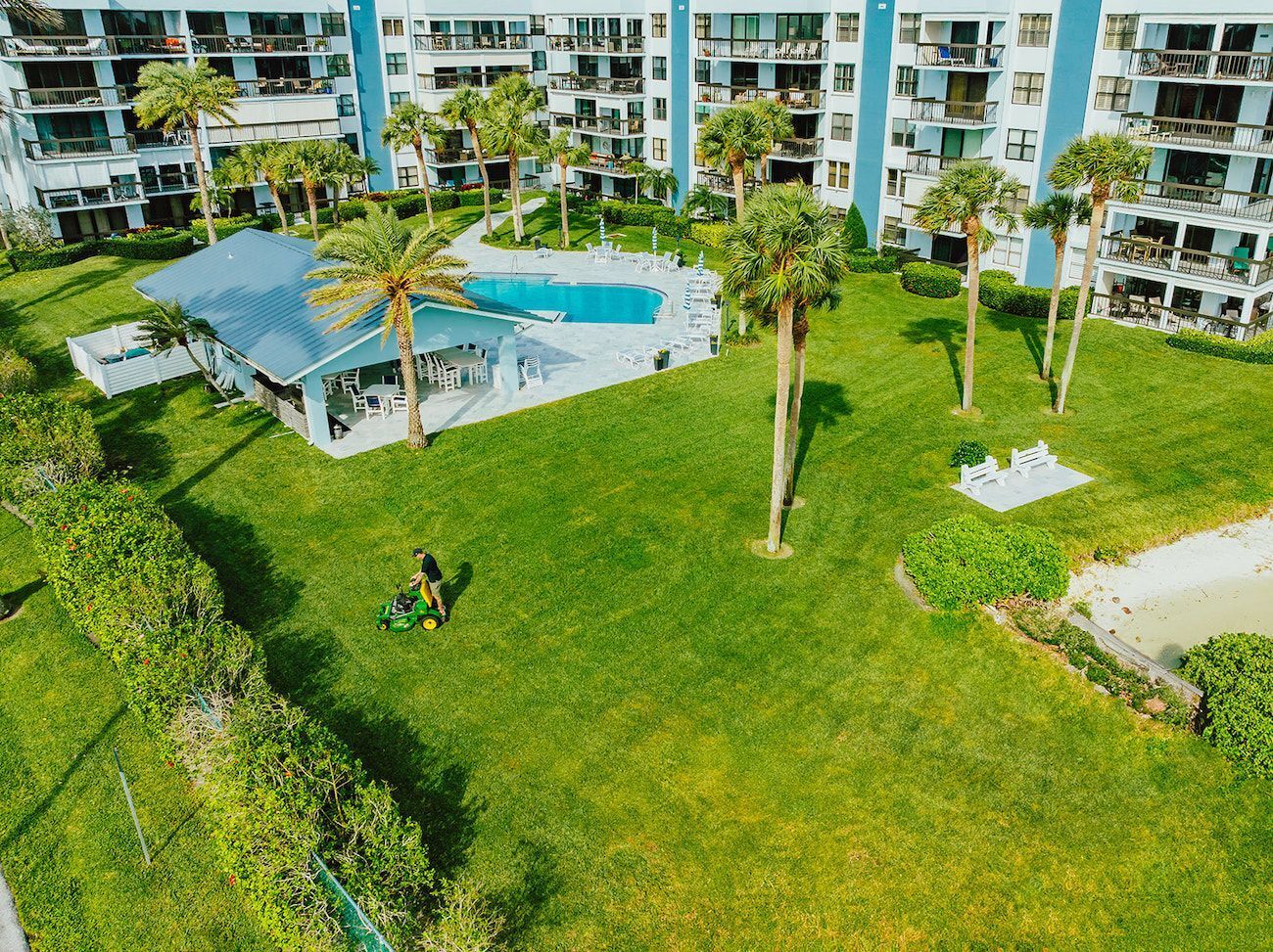 Commercial lawn maintenance crew mowing large HOA community landscape for commercial landscaping services in Boynton Beach, FL
